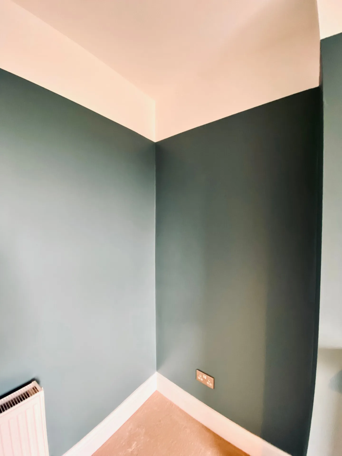Deep green painted bedroom walls with white skirting and a crisp ceiling line, painting in Kensington by coreMaint