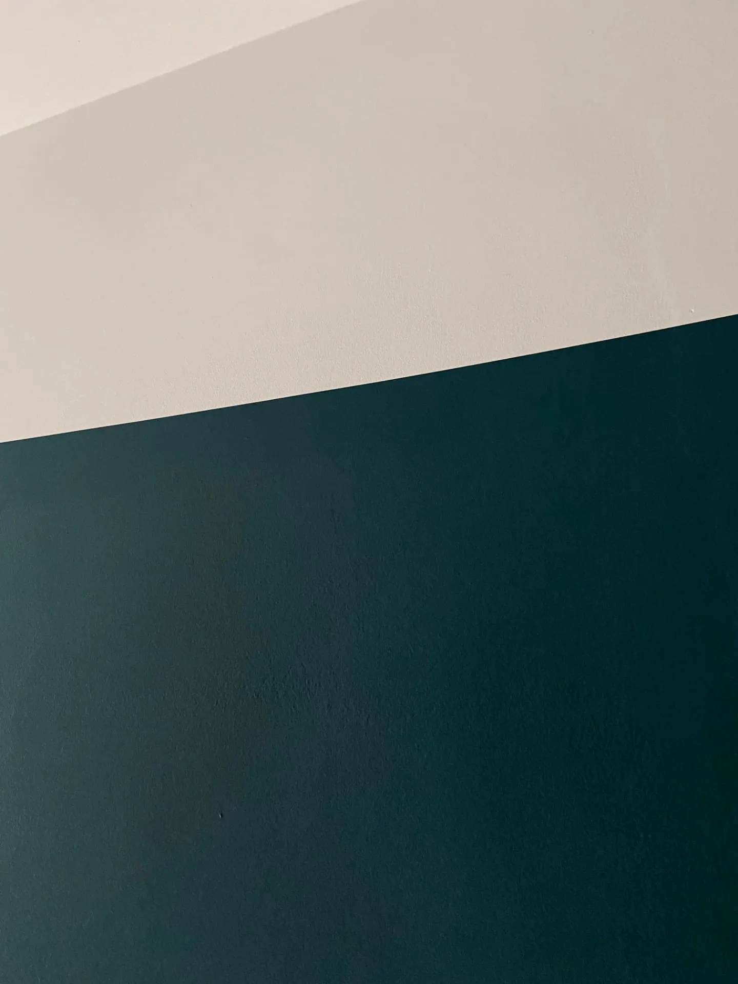 Close-up of a sharp cut-in line between cream and dark green wall paint, decorating in Chelsea by coreMaint