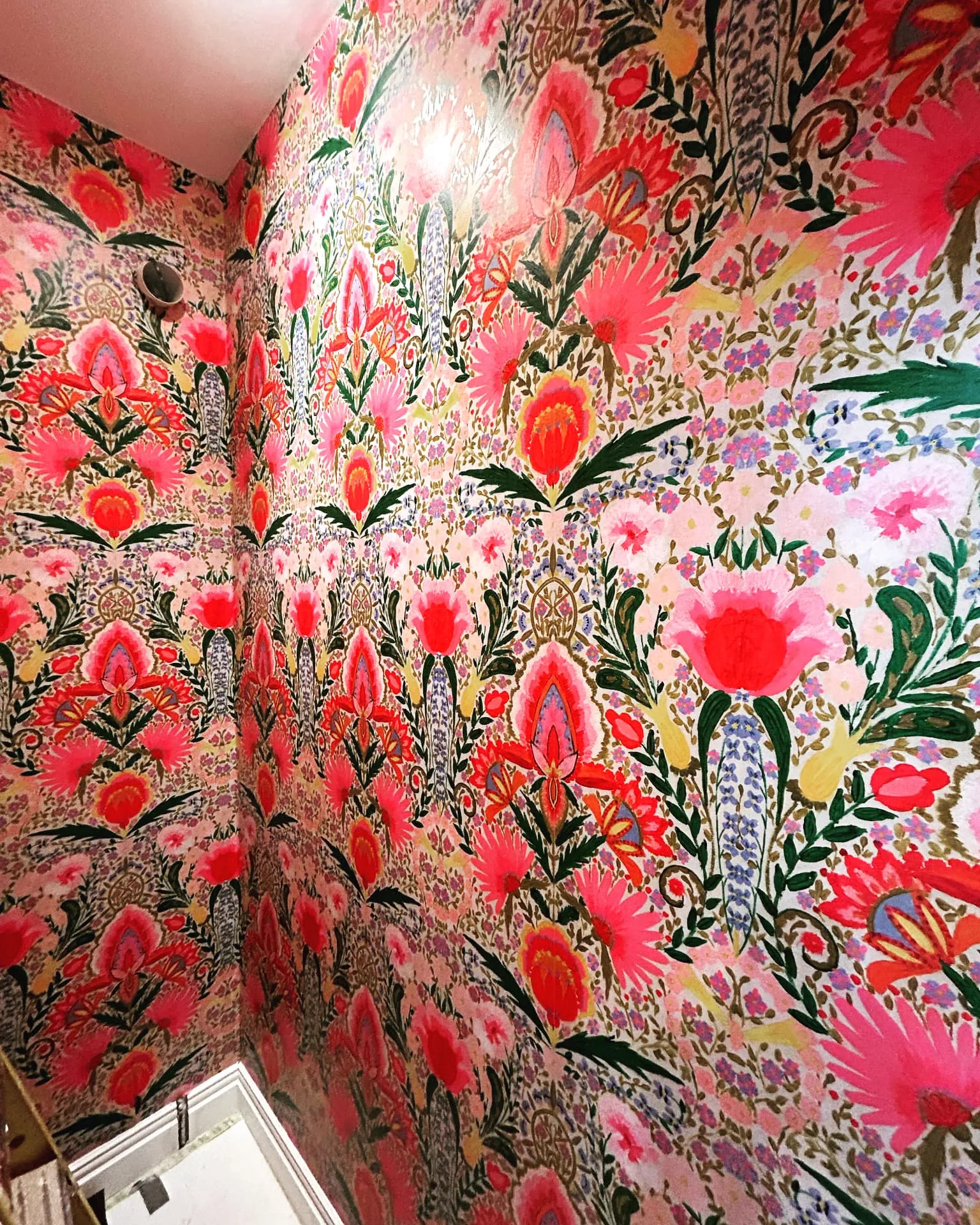 Bold pink and red floral wallpaper hung in a cloakroom toilet, wallpapering in St John's Wood by coreMaint